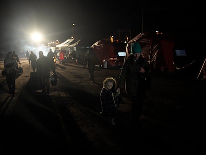 Refugiados que huyen de la guerra en  Ucrania caminan hacia un tren en el cruce fronterizo de Medyka, Polonia, el jueves 10 de marzo de 2022.