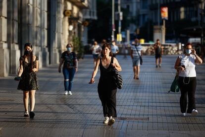 En el centro de la imagen, una mujer sin mascarilla por el centro de Barcelona.
