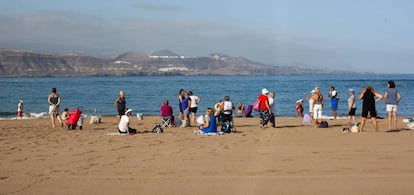 Turistas descansan en una playa.