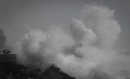 Varias personas observan el oleaje en el Paseo Nuevo de San Sebastián, donde se ha decretado la alerta naranja por impacto de olas en la costa.