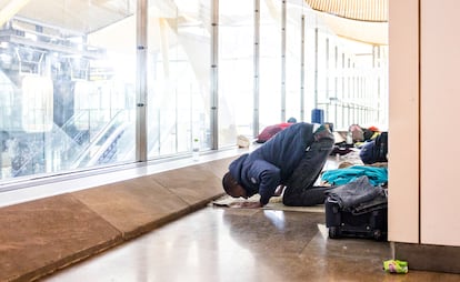 A traveler in transit prays on their way to Latin America, where they will continue on their path to the United States.