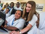 La enfermera Chesca Mbilinyi y Melinda Gates prueban un nuevo sistema digital para clasificar historiales de pacientes en el centro de salud de Magomeni de Dar es Salaam, en Tanzania, en junio de 2016 