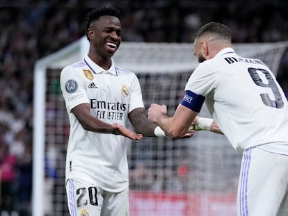 Real Madrid's Karim Benzema, right, celebrates with teammate Vinicius Junior after scoring his sides first goal during their Champions League, round of 16, second leg soccer match against Liverpool at the Santiago Bernabeu stadium in Madrid, Spain, Wednesday, March 15, 2023.