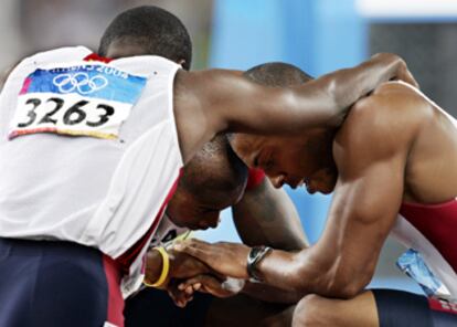 De izquierda a derecha, Gatlin (bronce); el ganador Shawn Crawford, y Williams (plata), agachados tras la carrera.