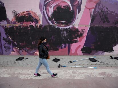 Una joven pasa junto al mural feminista situado en el distrito de Ciudad Lineal, en Madrid, el 8 de marzo de 2021.