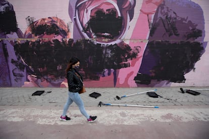 Una joven pasa junto al mural feminista situado en el distrito de Ciudad Lineal, en Madrid, el 8 de marzo de 2021.