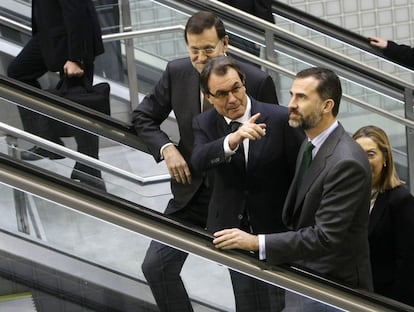 El presidente del Gobierno, Mariano Rajoy, el presidente de la Generalitat de Cataluña, Artur Mas, y el Príncipe Felipe en una escalera mecánica a su llegada a la Estación de Girona.