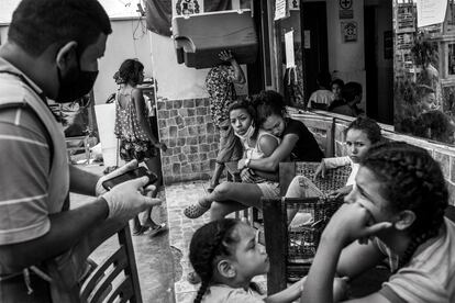 Hombres, mujeres y niños esperan en el patio del albergue Sin Fronteras el almuerzo del día. Ubicado en una vivienda de unos 200 metros cuadrados, este refugio del distrito de San Juan de Lurigancho, en Lima, acoge en la actualidad a unos 200 venezolanos sin recursos. Los alimentos que reciben son donaciones de distintas instituciones como el Banco de Alimentos. 