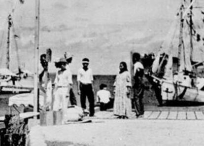 En el centro del grupo del malecón está la figura que History Channel apunta que pudo ser Amelia Earhart. A a izquierda, junto al poste, el supuesto Noonan.