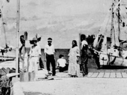 No centro do grupo no cais está a figura que o History Channel afirma que poderia ser Amelia Earhart. À esquerda, ao lado do poste, o suposto Noonan.