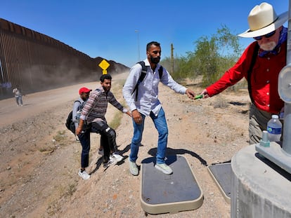 Migrants from India receive support from a volunteer after crossing the border in Arizona.