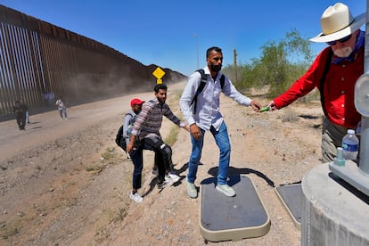 Migrants from India receive support from a volunteer after crossing the border in Arizona.