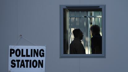 Dos personas en el interior de un centro de votaciones en la estación de tren de Norbiton, este jueves.