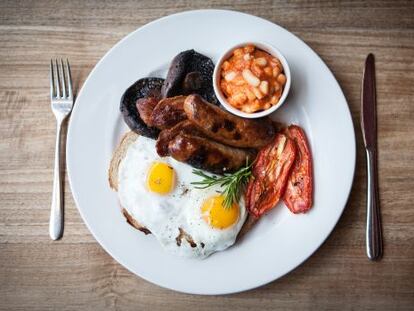 Desayuno ingl&eacute;s cl&aacute;sico: huevos, beicon, salchichas y alubias con tomate.