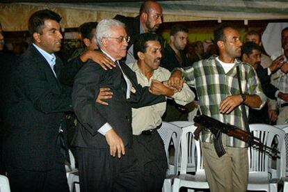 Mahmud Abbas abandona el lugar del tiroteo rodeado de guardaespaldas.