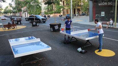 Dos amigos juegan al tenis de mesa en la supermanzana del Poblenou, en Barcelona.