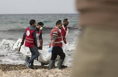 Varios cooperantes de la Media Luna Roja libia transportan el cuerpo de uno de los inmigrantes fallecidos que han sido hallados en la costa de Libia.