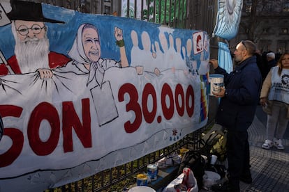Un hombre pinta un mural en referencia a las personas desaparecidas por la dictadura, este jueves en Buenos Aires.