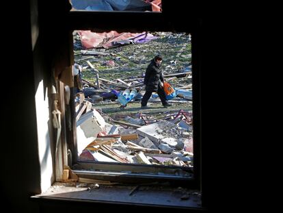 A woman pulls a cart with bottles of water past the building of a theatre destroyed in the course of Ukraine-Russia conflict in the southern port city of Mariupol, Ukraine April 7, 2022. REUTERS/Alexander Ermochenko