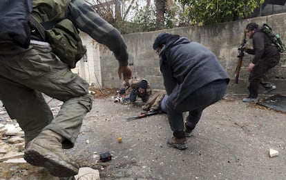 Miembros del Ejército Libre de Siria ayudan a uno de sus compañeros que momentos antes ha sido herido de bala por un francotirador sirio en las calles de Damasco.