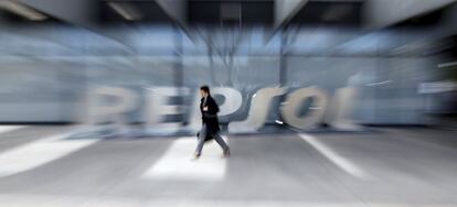 File photo of a woman walking past the logo of Spanish oil major Repsol at its headquarters in Madrid