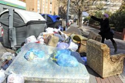 Una mujer se dispone a depositar una bolsa de basura junto a varios contenedores que acumulan gran cantidad de residuos, hoy en una calle del centro de Granada. Las calles de Granada capital acumulan ya más de 700 toneladas de residuos a consecuencia de la huelga que secunda la plantilla de la concesionaria del servicio de limpieza y recogida de basura, que en la cuarta jornada de conflicto laboral ha dado por rotas -de momento- las negociaciones con la empresa Inagra.