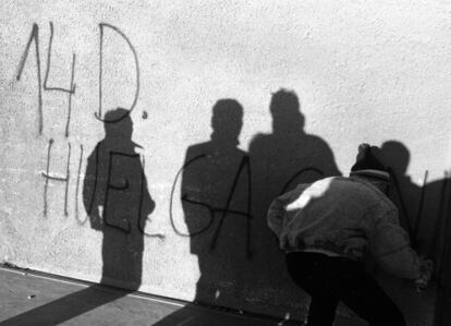 Un joven hace una pintada en una pared durante la huelga general del 14-D de 1988 contra la política económica del gobierno de Felipe González.