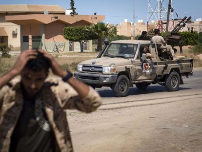 Un combatiente leal al Gobierno de Acuerdo Nacional (GNA) de Libia, reconocido internacionalmente, se tapa los oídos cuando otros soldados se preparan para disparar a unos 40 kilómetros al sur de la capital, Trípoli, el 29 de abril de 2019.
