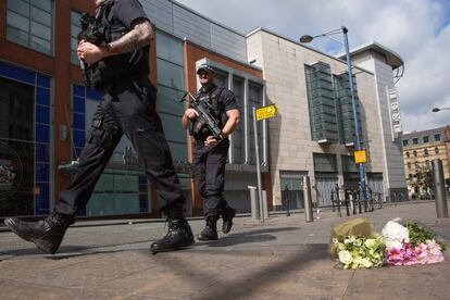 MANCHESTER, ENGLAND - MAY 23:  Armed police patrol on Shudehill walking past the first floral tributes to the victims of the terrorist attack on Shudehill, May 23, 2017 in Manchester, England. An explosion occurred at Manchester Arena as concert goers were leaving the venue after Ariana Grande had performed. Greater Manchester Police are treating the explosion as a terrorist attack and have confirmed 22 fatalities and 59 injured.  (Photo by Christopher Furlong/Getty Images)