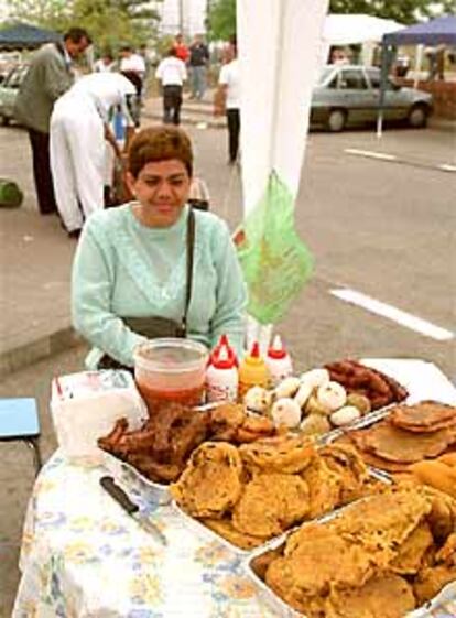 Una mujer colombiana vende comida junto al hospital 12 de Octubre en Madrid.