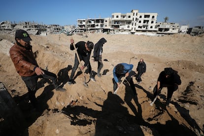 Varias personas buscan cadveres enterrados en el cementerio de Shejaia, destruido por los tanques israeles, el lunes en Ciudad de Gaza.