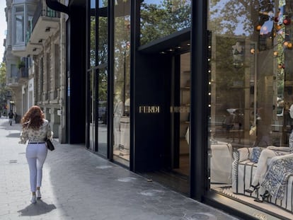 Una dona passa per davant d'algunes de les botigues de luxe del passeig de Gràcia.