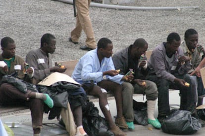 Varios inmigrantes descansan tras ser detenidos a su llegada a Ceuta.