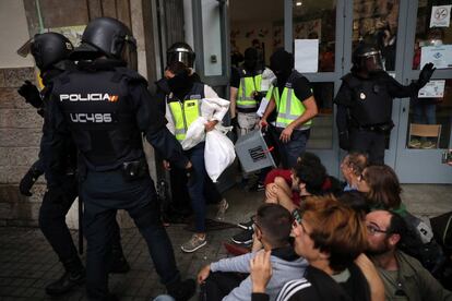 Agents de la policia retiren urnes de l'Institut Jaume Balmes de Barcelona.