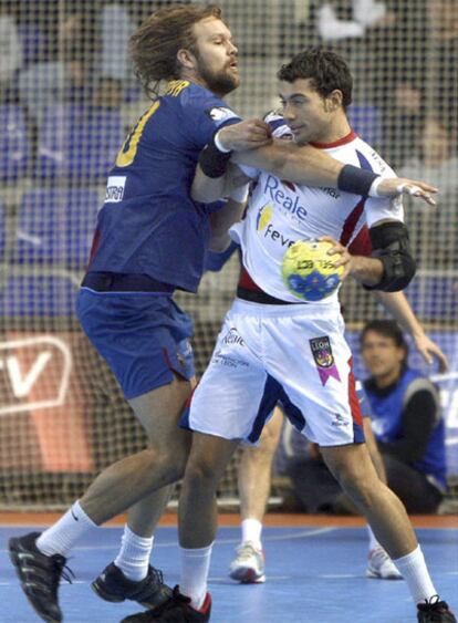 El jugador del FC Barcelona Borges Magnus Jermenyr (i), intenta robar el balón a Daniel Sarmiento, del Reale Ademar León, durante la final de la Copa Asobal de balonmano jugada esta tarde en el Palau Blaugrana de Barcelona.