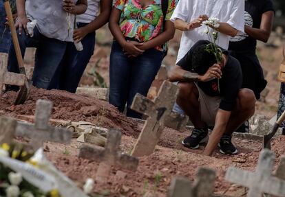 Un hombre llora en un funeral en Río de Janeiro, Brasil, tras la muerte de una mujer por covid-19.