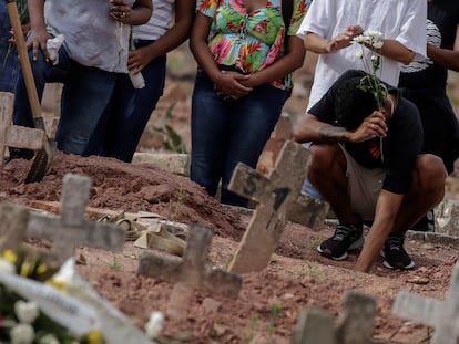 Un hombre llora en un funeral en Río de Janeiro, Brasil, tras la muerte de una mujer por covid-19.