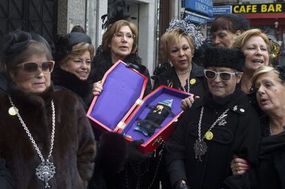 Mujeres de luto desfilan para despedir los carnavales en la tradicional procesión festiva del Entierro de la Sardina en Madrid.