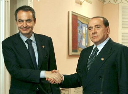El presidente español, José Luis Rodríguez Zapatero, estrecha la mano con su homólogo italiano, Silvio Berlusconi.