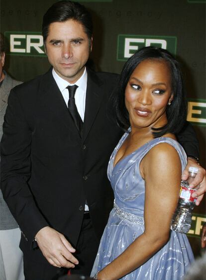 El actor John Stamos posa junto a Angela Baset en la entrada de la fiesta que se celebró anoche en Hollywood para celebrar el final de la serie 'Urgencias', que lleva 15 años en antena y que sirvió para descubrir al mundo, entre otros, al actor George Clooney.