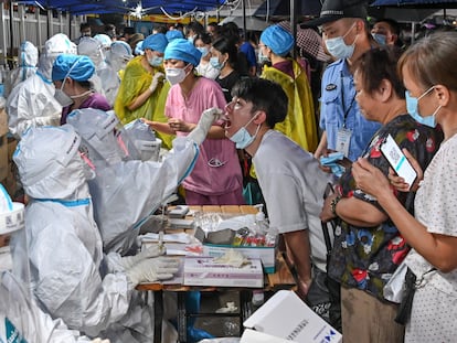 Agentes sanitários fazem exames maciços de covid-19 em Cantão (China), no domingo.