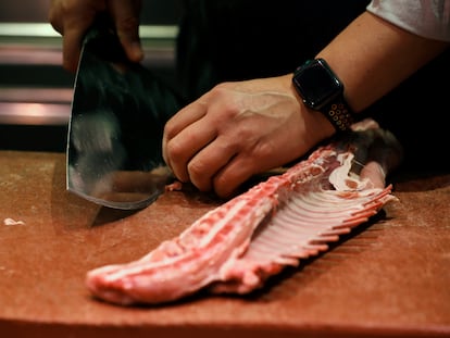 Un carnicero prepara chuletas en el mercado de Chamartín de Madrid.