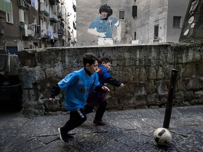 Dos niños, con las camisetas de Maradona y Messi, juegan en el barrio Napolitano de Forcella.