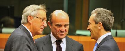 Guindos, en medio de Juncker y el ministro italiano de Economía.