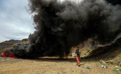Un yemení pasa junto a una hoguera donde arden sustancias narcóticas incautadas por las fuerzas de seguridad leales a los rebeldes Huthi, en la capital controlada por los rebeldes, Sanaa, este miércoles.