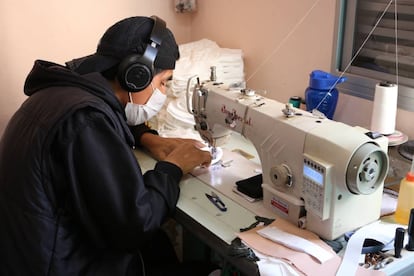 Un empleado trabaja con una mascarilla y auriculares para proteger sus vías respiratorias y oídos