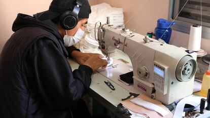 Un empleado trabaja con una mascarilla y auriculares para proteger sus vías respiratorias y oídos