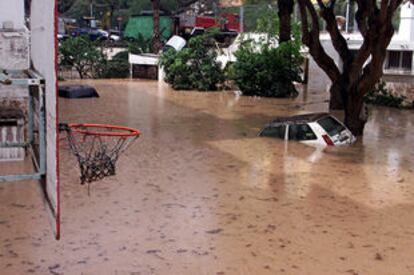 Un turismo permanecía ayer sumergido en el agua en una cancha de baloncesto inundada por la lluvia torrencial caída en Santa Cruz de Tenerife.