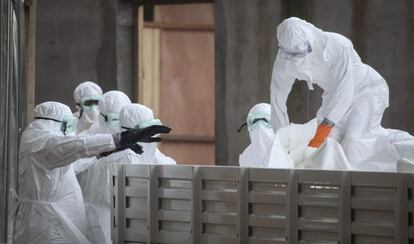 Enfermeiras na Libéria preparam corpos de vítimas do ebola.