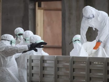 Enfermeiras na Libéria preparam corpos de vítimas do ebola.